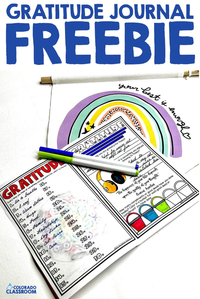 A gratitude journal lies open to two completed pages with writing and coloring. Two markers lie on top. "Gratitude Journal Freebie" is across the top.