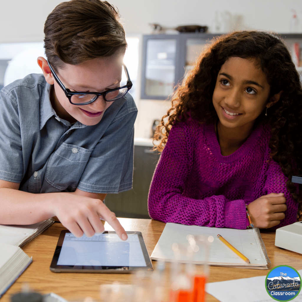 This image shows two middle school students working on an experiment together.