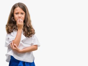 Brunette hispanic girl looking stressed and nervous with hands on mouth biting nails. Anxiety problem.